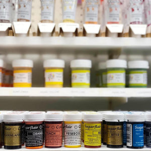 An image of several shelves of various different vibrant food colourings in small pots.